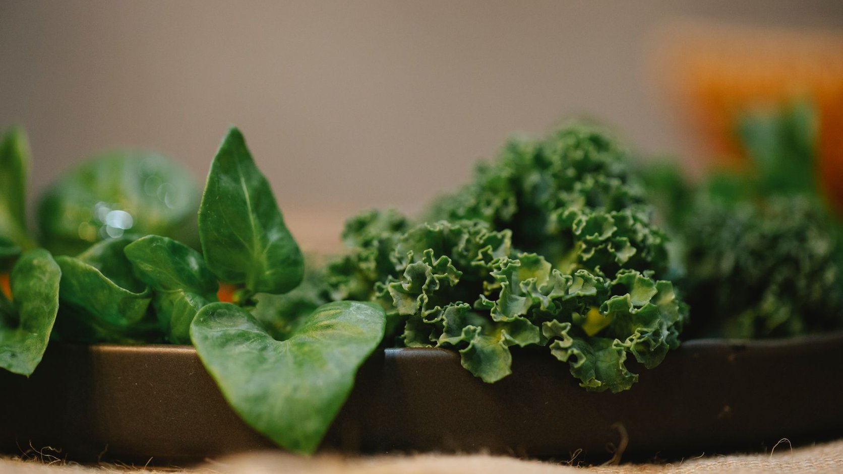 Folhas verde-escuras como espinafre e couve, fontes de ferro vegetal, sobre a mesa da cozinha