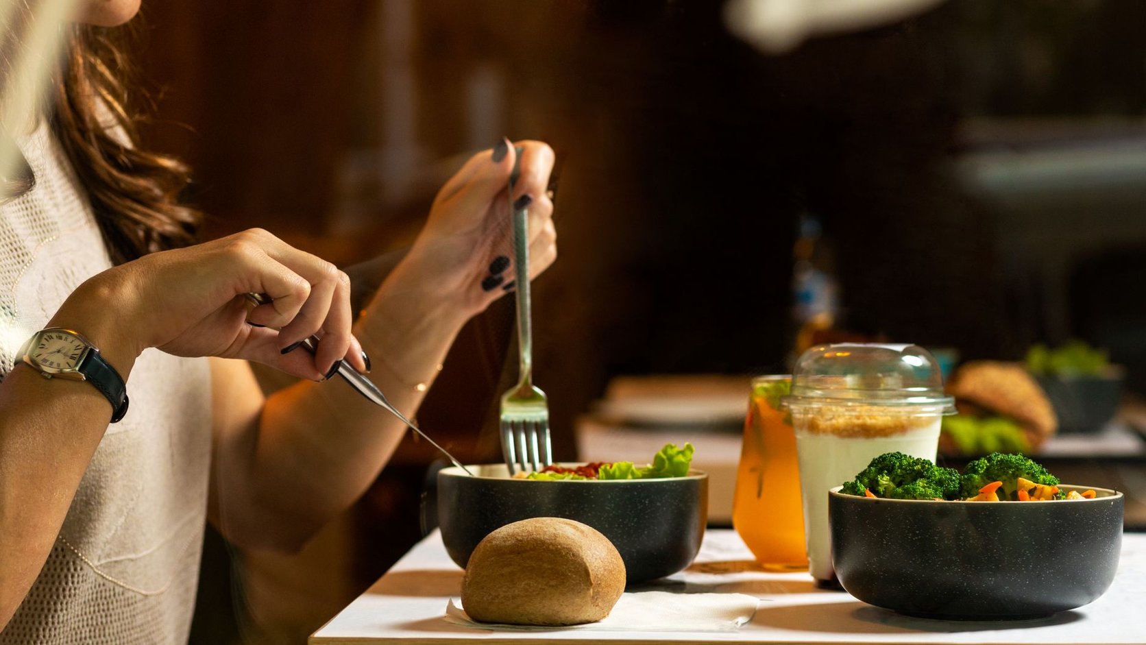 Mulher almoçando salada fresca com vegetais coloridos em ambiente interno