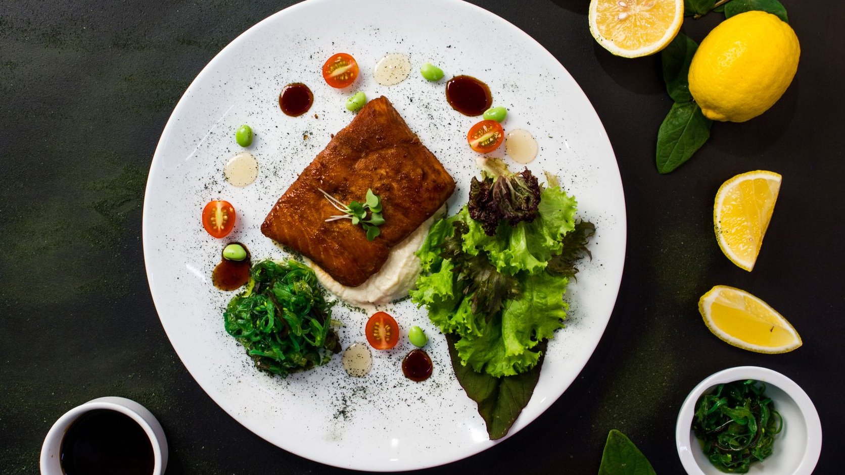 Peixe grelhado servido com salada fresca e espinafre em prato branco