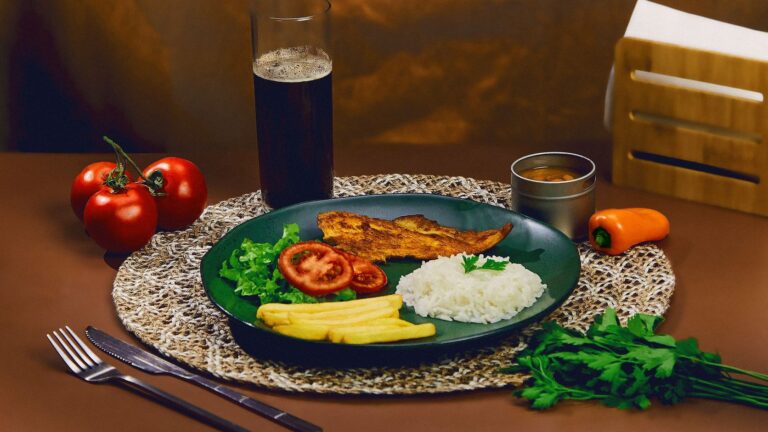 Prato brasileiro colorido e equilibrado com peixe fresco, arroz e vegetais variados.