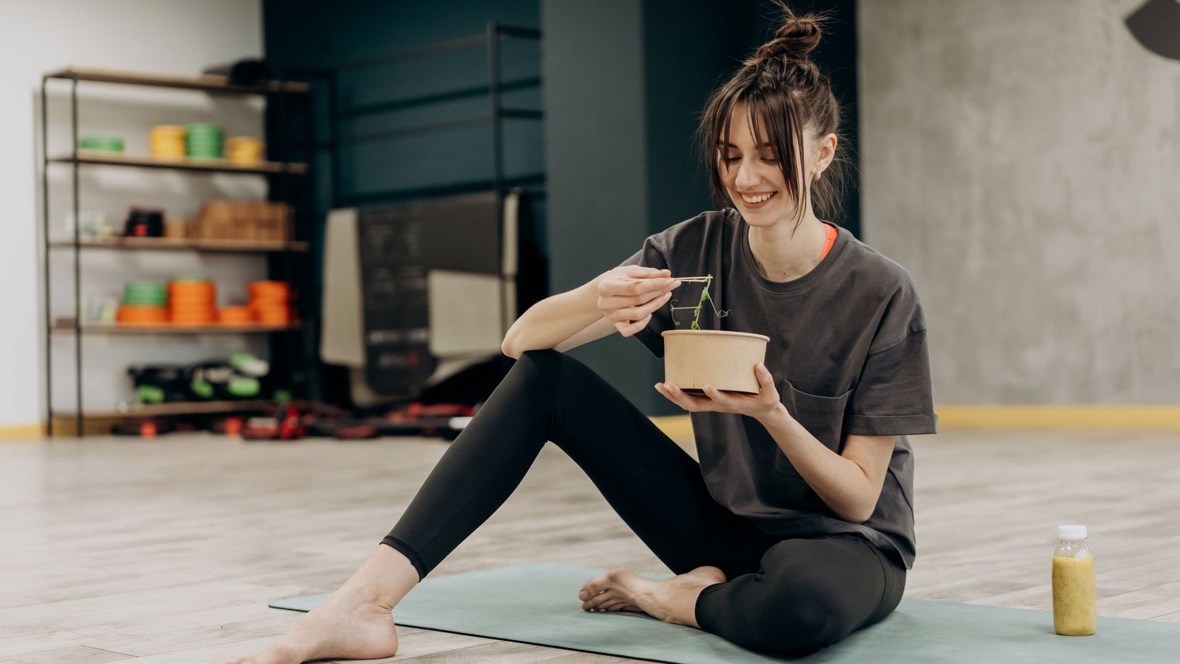 Mulher saboreando uma tigela de salada colorida com vegetais e fontes de energia equilibrada.