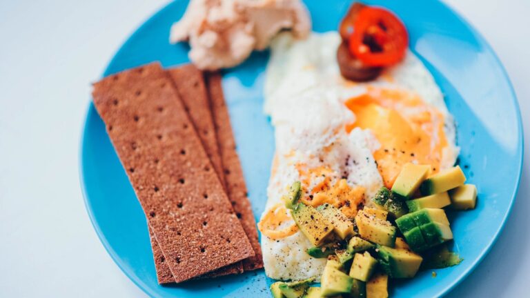 Prato saudável de café da manhã com ovos, abacate e ingredientes nutritivos.