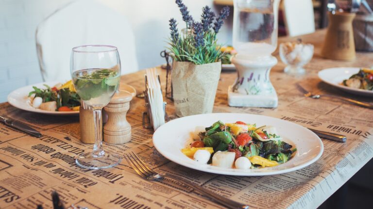 Prato saudável com salada fresca, vegetais variados e um copo de água à mesa.